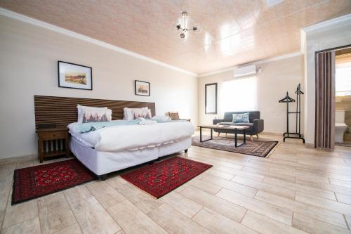 a bedroom with a bed and a chair and a table at Tintswalo Elegant Apartments in Giyani