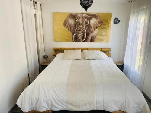 ein Schlafzimmer mit einem Bett mit einem Bild eines Elefanten in der Unterkunft Villa accueillante avec piscine à Saint-Paul-et-Valmalle in Saint-Paul-et-Valmalle