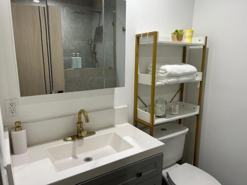 a bathroom with a sink and a toilet and a mirror at Newly Built Stylish Modern 2B In LA in North Sherman Way