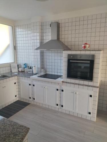 a kitchen with white cabinets and a microwave at AriadiMare in Torre Ovo