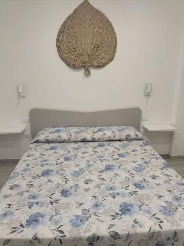 a bed with a blue and white comforter on it at AriadiMare in Torre Ovo