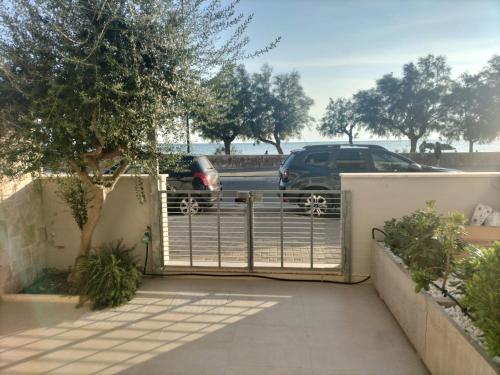 a gate with a car parked in a parking lot at AriadiMare in Torre Ovo