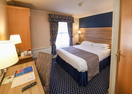 a hotel room with a bed and a desk at The Queens Hotel & Victoria Cloisters Apartments in York