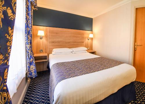 a hotel room with a bed and a window at The Queens Hotel & Victoria Cloisters Apartments in York