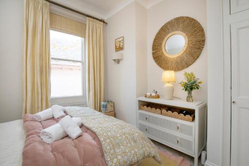 a bedroom with a bed and a mirror and a window at Admirals Hard in Budleigh Salterton