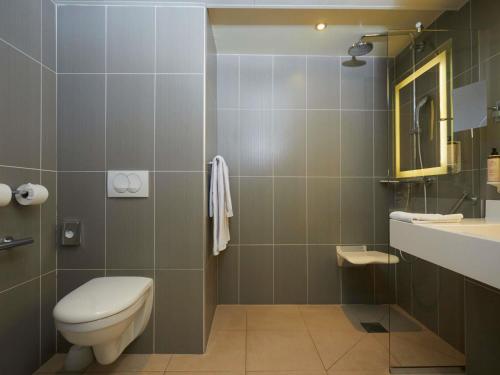 a bathroom with a toilet and a sink at Mercure Arras Centre Gare in Arras