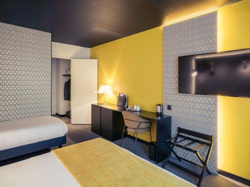a hotel room with a bed and a desk at Mercure Arras Centre Gare in Arras