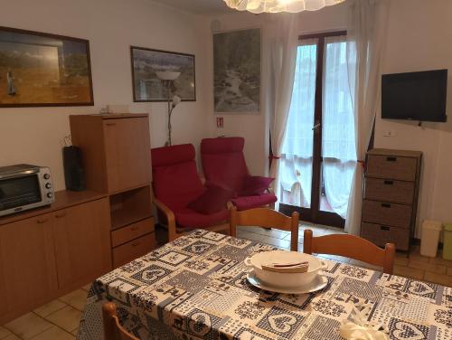 a living room with a table and chairs and a television at Piera' s House in Caderzone
