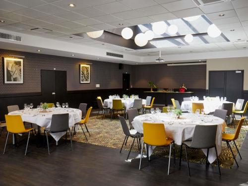 a conference room with white tables and yellow chairs at Mercure Arras Centre Gare in Arras