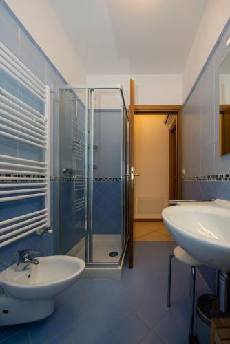 a bathroom with a glass shower and a sink at ApartmentsGarda - Canevini Residence in Torri del Benaco