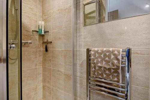 East CarletonにあるPelican Eco Lodgeのシャワー(ガラスドア付)、タオルが備わります。