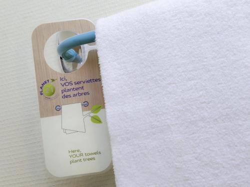 a roll of white towels on a wooden holder at ibis Bordeaux Centre - Gare Saint-Jean in Bordeaux