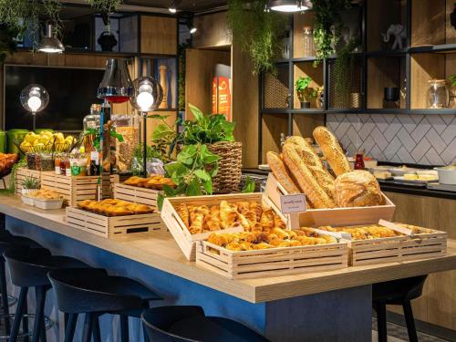 a display of bread and pastries on a table in a store at ibis Bordeaux Centre - Gare Saint-Jean in Bordeaux
