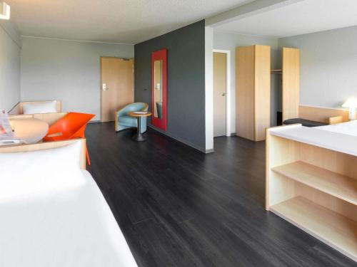 a room with a bed and a couch and a table at ibis Saint Dizier in Saint-Dizier