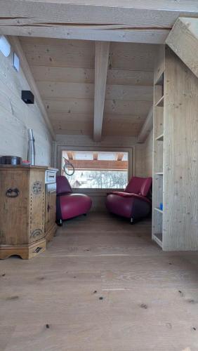 una stanza con due letti rossi in una stanza con una finestra di Le Chalet MontBlanc a Bionnay