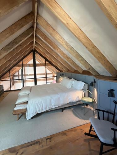 una camera da letto con un letto grande in una mansarda di The Barn at Stonewalls - Farm stay in 25 acres a Musk