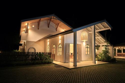 a house lit up at night with a lit up at Solara Beach House in Tangalle