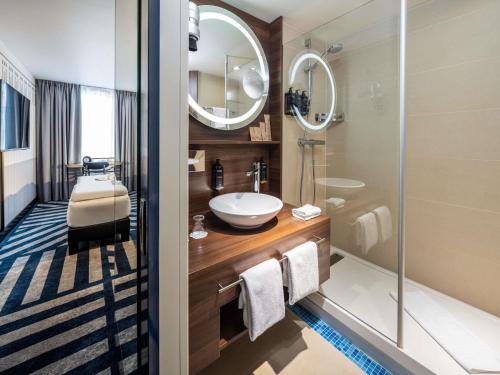 a bathroom with a sink and a mirror at Hotel Mercure Wien City in Vienna