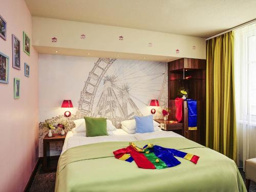 a bedroom with a large bed with clothes on it at Hotel Mercure Wien City in Vienna