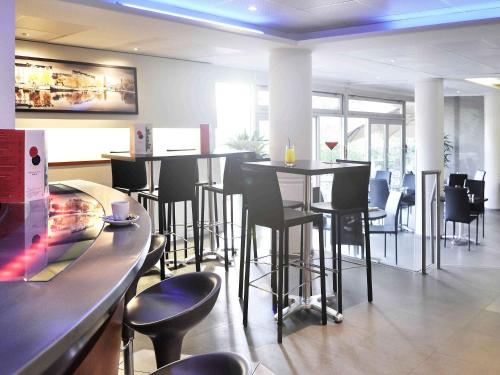 a bar with black stools in a restaurant at Novotel Nantes Centre Gare in Nantes
