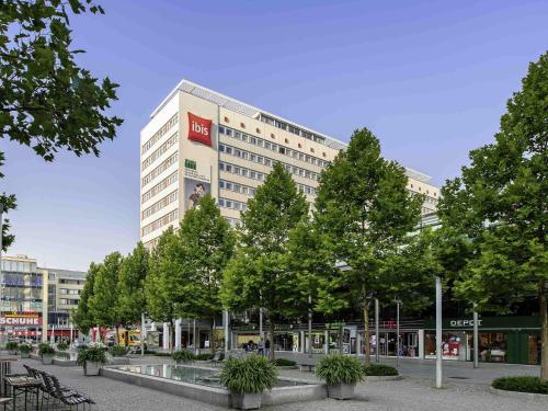 a tall building with trees in front of it at ibis Dresden Zentrum in Dresden
