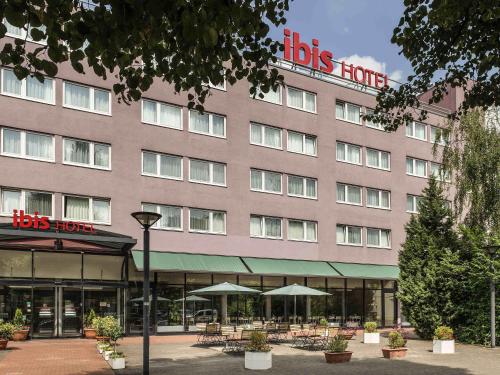 a hotel with tables and umbrellas in front of it at ibis Berlin City Nord in Berlin