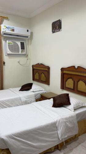 a room with two beds and a air conditioner at جمانا سويتس للشقق المخدومه in Al Qunfudhah