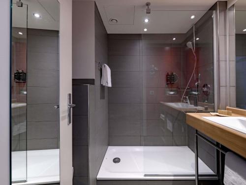 a bathroom with a shower and a sink at Mercure Hotel Stuttgart Airport Messe in Stuttgart