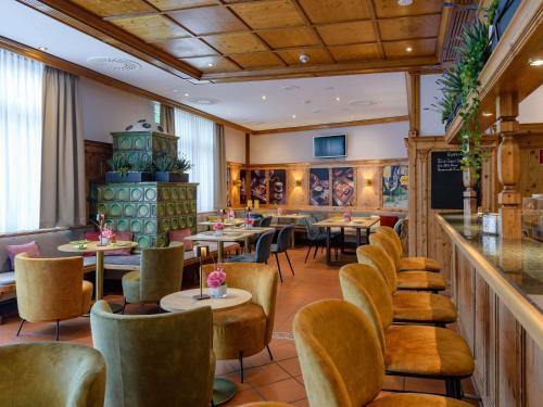 a restaurant with tables and chairs and a bar at Mercure Hotel Stuttgart Airport Messe in Stuttgart