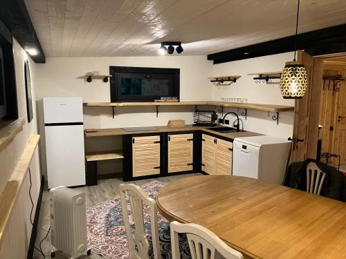 a kitchen with a table and a sink and a refrigerator at Neitsijärve majutus in Otepää