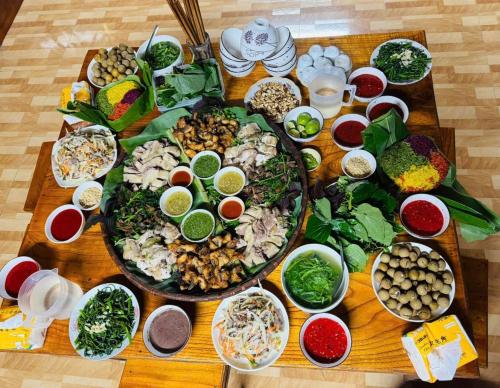 a wooden table with a bunch of food on it at Homestay trọng hiếu in Na Tong