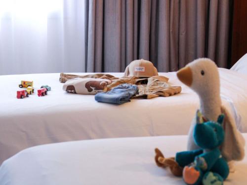 a baby crib with toys on a bed at Hotel Mercure Toulouse Centre Compans in Toulouse
