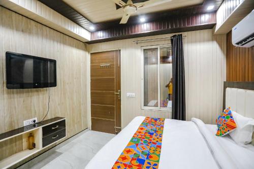 a bedroom with a bed and a television in it at FabHotel JMS Residency in Dehradun