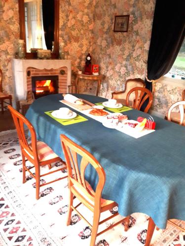 una sala da pranzo con tavolo, sedie e camino di Château Picol entre Futuroscope et Châteaux de la Loire a Lencloître