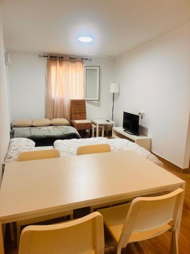 a room with a table and chairs and a living room at Casita de campo in Albacete