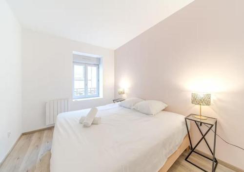 ein weißes Schlafzimmer mit einem weißen Bett und einem Fenster in der Unterkunft Rooftop d'exception, vue Rhône, 6 personnes, Caluire in Caluire-et-Cuire