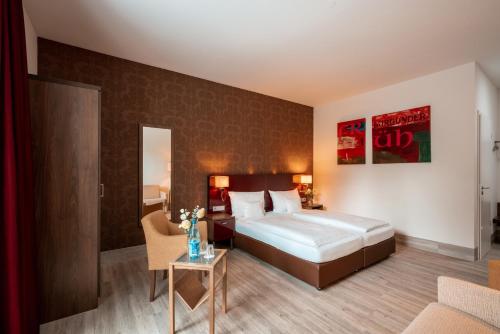 a hotel room with a bed and a table at Weinhotel Wasem in Ingelheim am Rhein