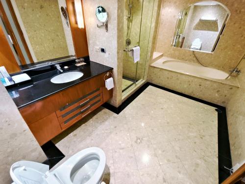 a bathroom with a sink and a toilet and a shower at The Davis Bangkok in Bangkok