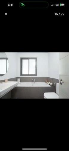 a bathroom with a tub and a toilet and a sink at RDC Villa avec Jardin & Piscine Privée in El Aouina Station