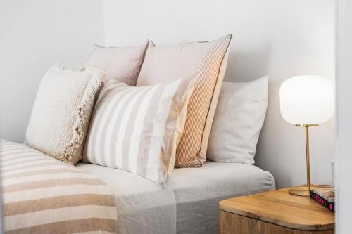 a couch with pillows and a table with a lamp at The Piccolo Cottage in Hobart