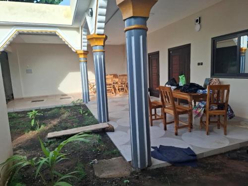 une terrasse avec colonnes et table dans une maison dans l'établissement Maison de vacances, à Gbouamé