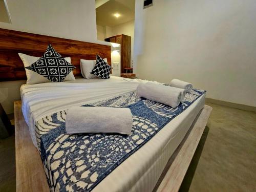a large bed with pillows on it in a room at Solara Beach House in Tangalle