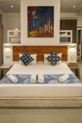 a bedroom with a large bed with blue and white pillows at Solara Beach House in Tangalle