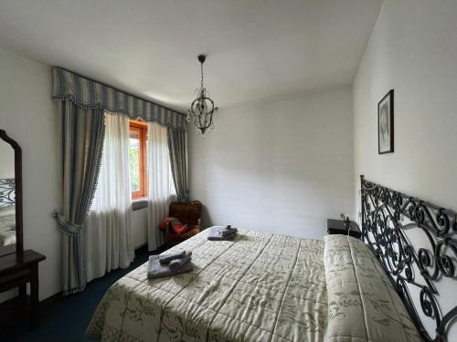 a bedroom with a bed and a chair and a window at Ampio appartamento per 8 a due passi dal centro in Bardonecchia