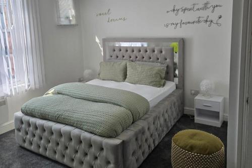 a bedroom with a large bed with a headboard at 1 Bed - Sleeps 4 - City Centre in Wolverhampton