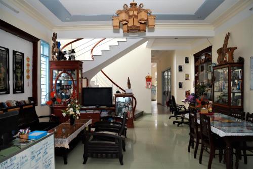 a room with chairs and tables and a chandelier at Areca Homestay in Hoi An