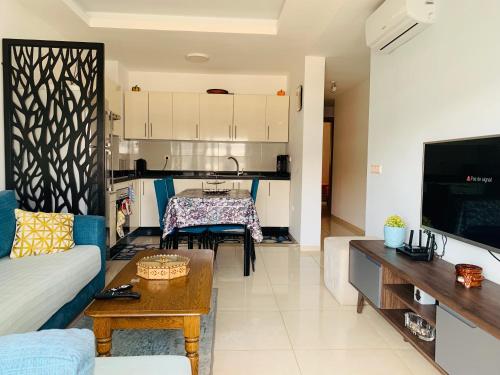 a living room with a couch and a table at Sunset Eden sea view in Aourir