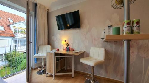 Una habitación con un escritorio y un televisor en la pared. en Exclusive Stay Augsburg 4 Minuten zur Messe, en Augsburg