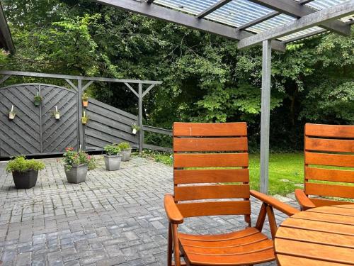 a patio with two chairs and a table and a pergola at Ferienwohnung Roskam 95170 in Rhauderfehn