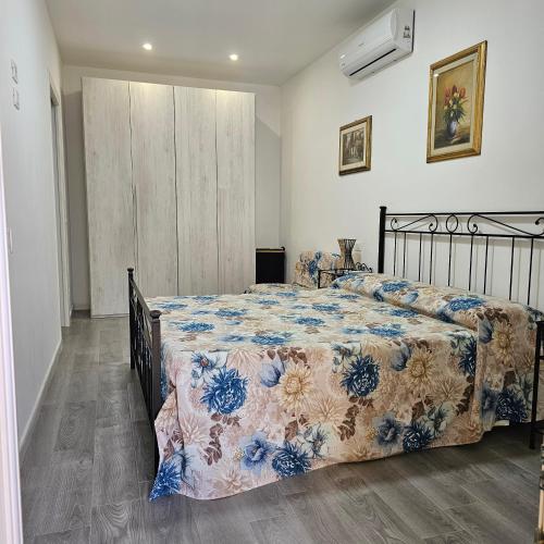 a bedroom with a bed with a comforter on it at TinaToni Apartment in Follonica
